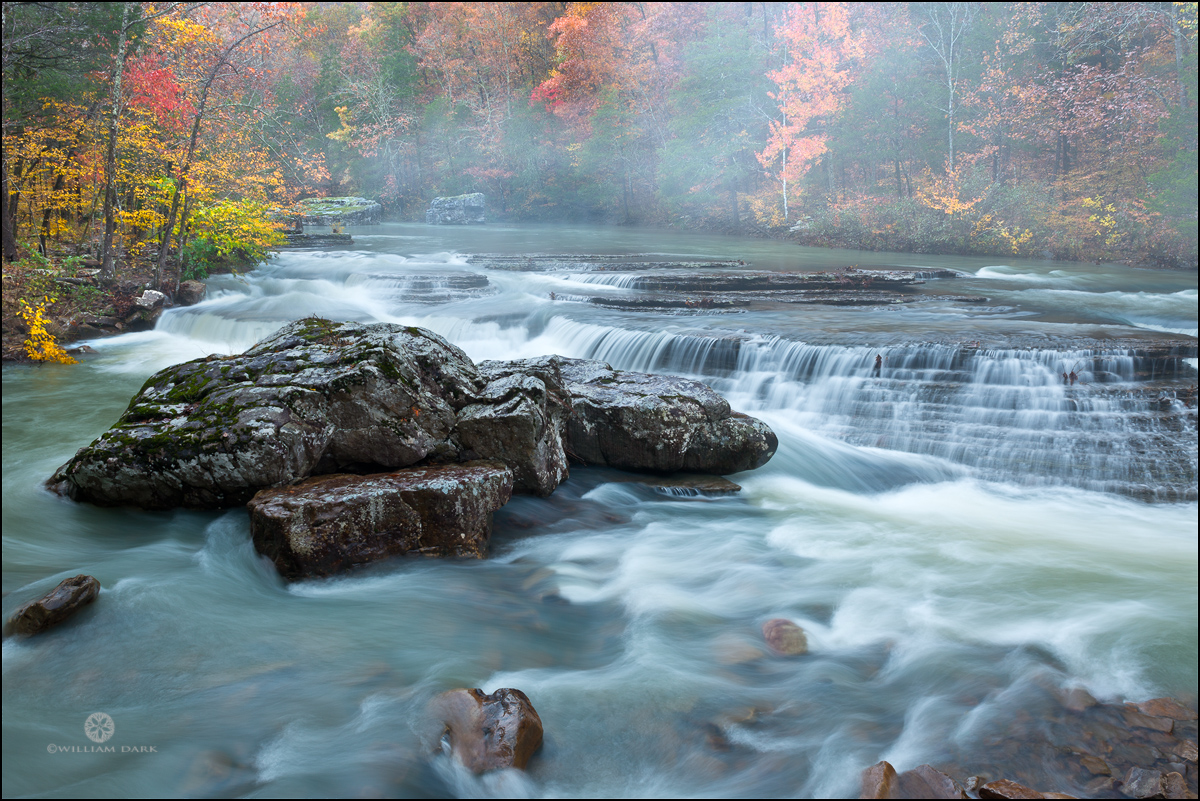 Early morning fog lifts from the water at Six Finger Falls in the Arkansas Ozarks.